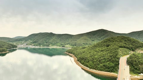 Cloudy lagoon with forested hills — Stillmotion