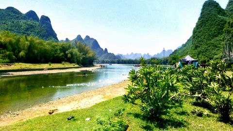 Lush karst hills along riverbank — Stillmotion