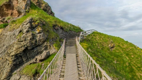 Rope bridge over coastal cliffs — Stillmotion