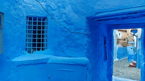 Blue-painted alley with wooden doors — Stillmotion