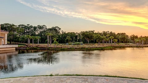 Resort garden beside a reflective lake — Stillmotion