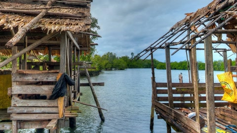 Rustic seaside huts over calm water — Stillmotion