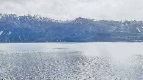 Lakeside village beneath mountains — Stillmotion