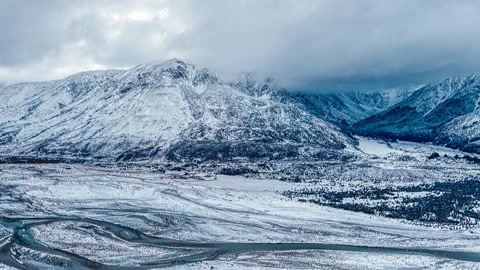 Snow-covered mountains around frozen plain — Stillmotion