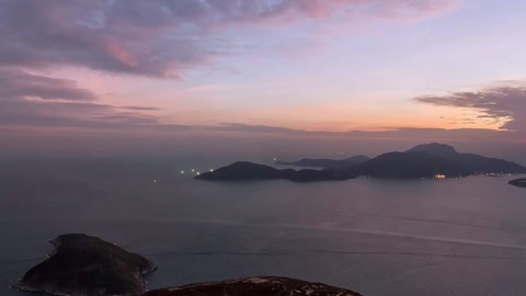 Islet at sunset over coastal city — Stillmotion