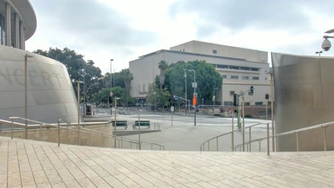 Outdoor museum entrance with curved glass facade — Stillmotion