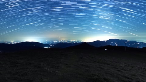 Star trails over dark mountain ridges — Stillmotion