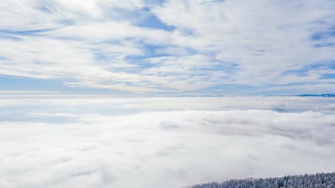 Snow-covered mountain ridge above clouds — Stillmotion