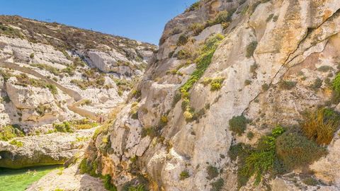 Rocky coastal canyon with blue water — Stillmotion