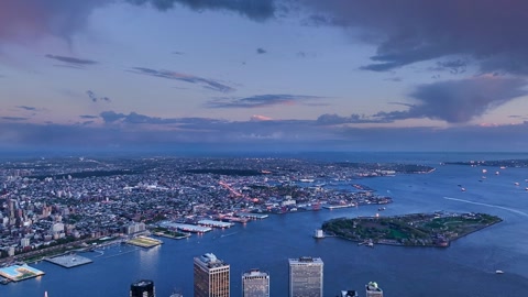 Aerial cityscape over harbor at sunset — Stillmotion