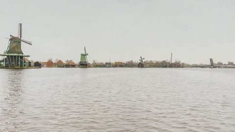 Windmills beside calm waters — Stillmotion