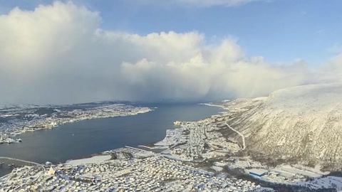 Snowy mountain overlook above coastal water — Stillmotion