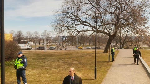 People walking near historic stone tower — Stillmotion