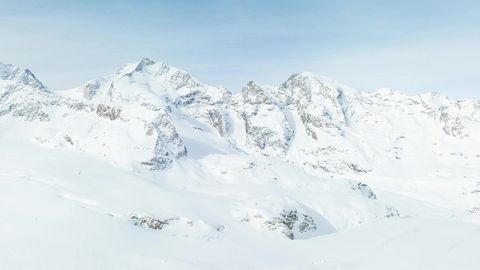 Snowy mountain range under blue sky — Stillmotion