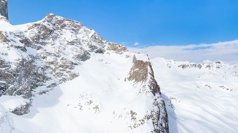 Snowy mountain range under blue sky — Stillmotion