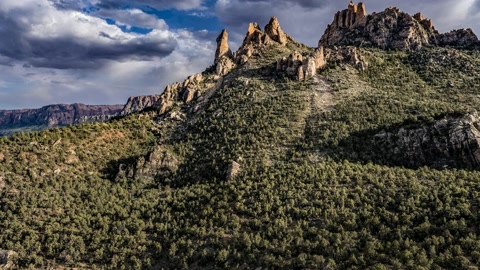 Forest-covered butte and canyon cliffs — Stillmotion