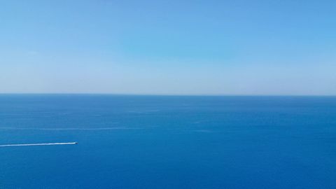 Rocky sea cliffs over blue water — Stillmotion