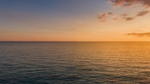 Cliff above calm sea at sunset — Stillmotion