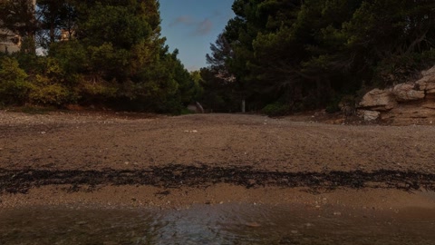 Rocky cliff by calm water — Stillmotion