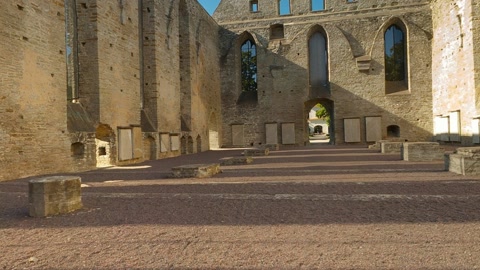 Man holding sword in ruined stone hall — Stillmotion