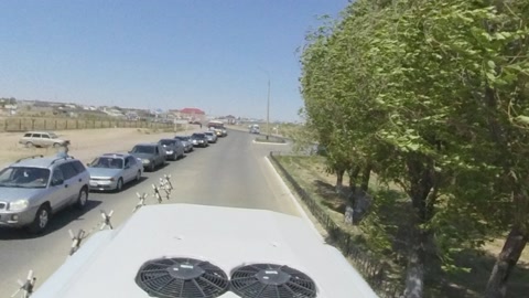 Sandy desert road with trees and buildings — Stillmotion