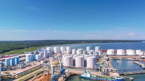 Industrial port with storage tanks and cranes — Stillmotion