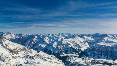 Snowy mountain range under blue sky — Stillmotion