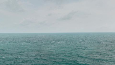 Cloudy ocean beside rocky shore — Stillmotion