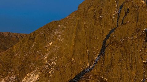 Sunlit coastal cliff over sea — Stillmotion