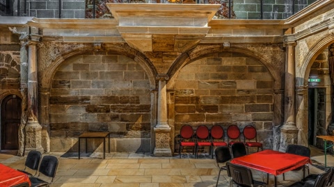 Historic stone hall with red tables — Stillmotion