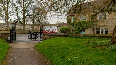 Churchyard with stone buildings and trees — Stillmotion