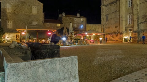 Nighttime stone plaza with historic buildings — Stillmotion