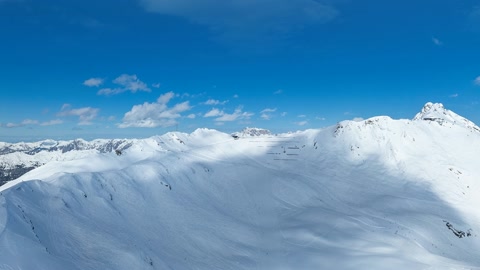 Snow-covered mountain range under blue sky — Stillmotion