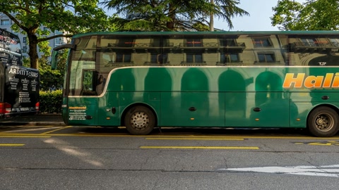 Urban street with buses and storefronts — Stillmotion